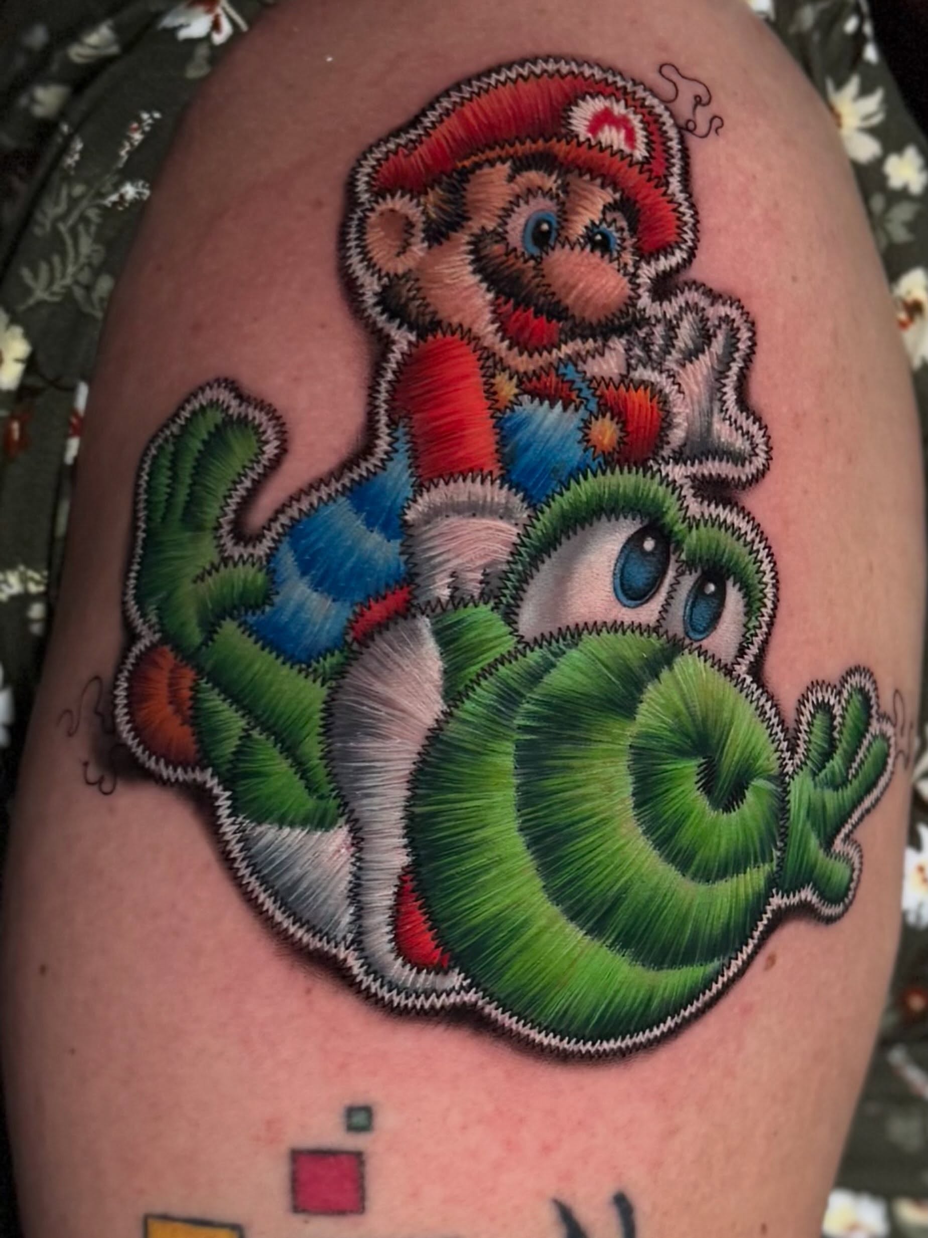 Colour tattoo designed like an embroidered character patch by Julia Luniko in Winnipeg