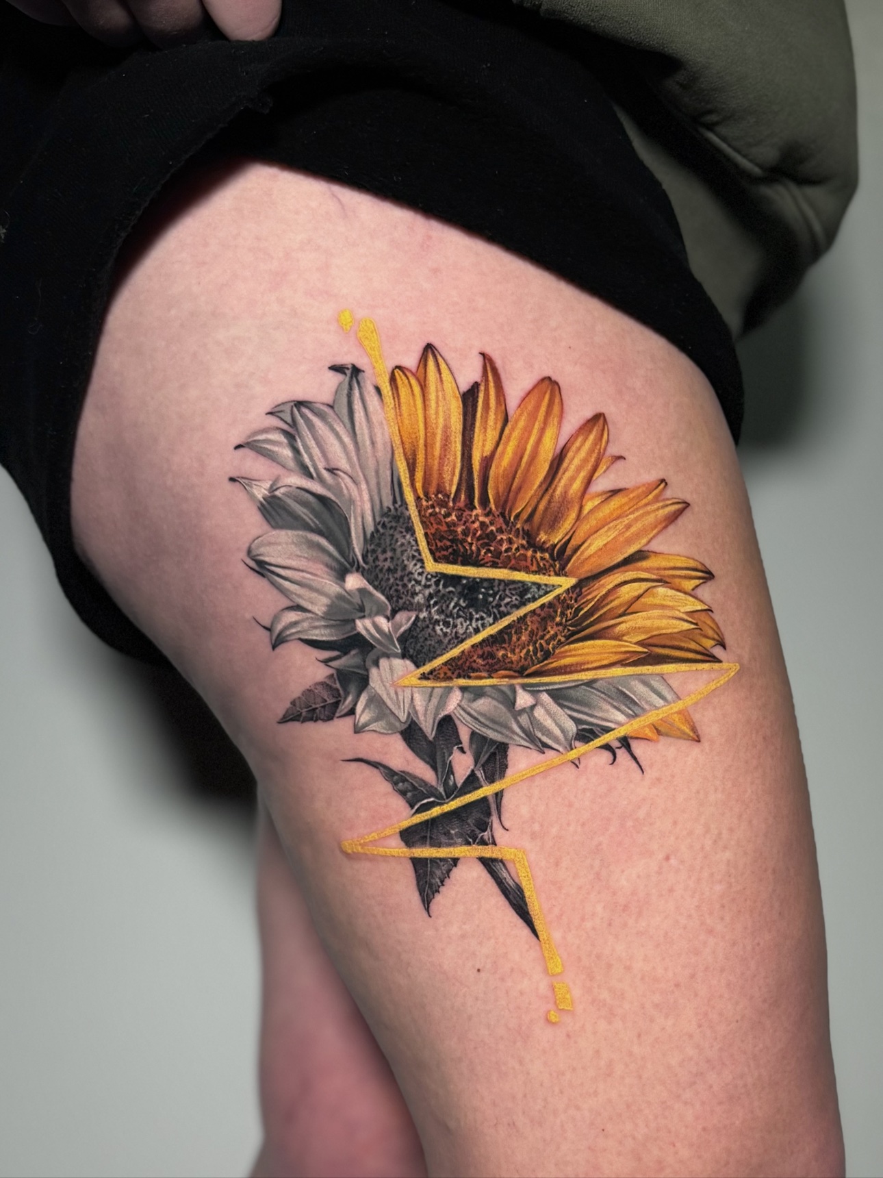 Half-colour, half-black-and-grey sunflower tattoo by Winnipeg tattoo artist Julia Luniko