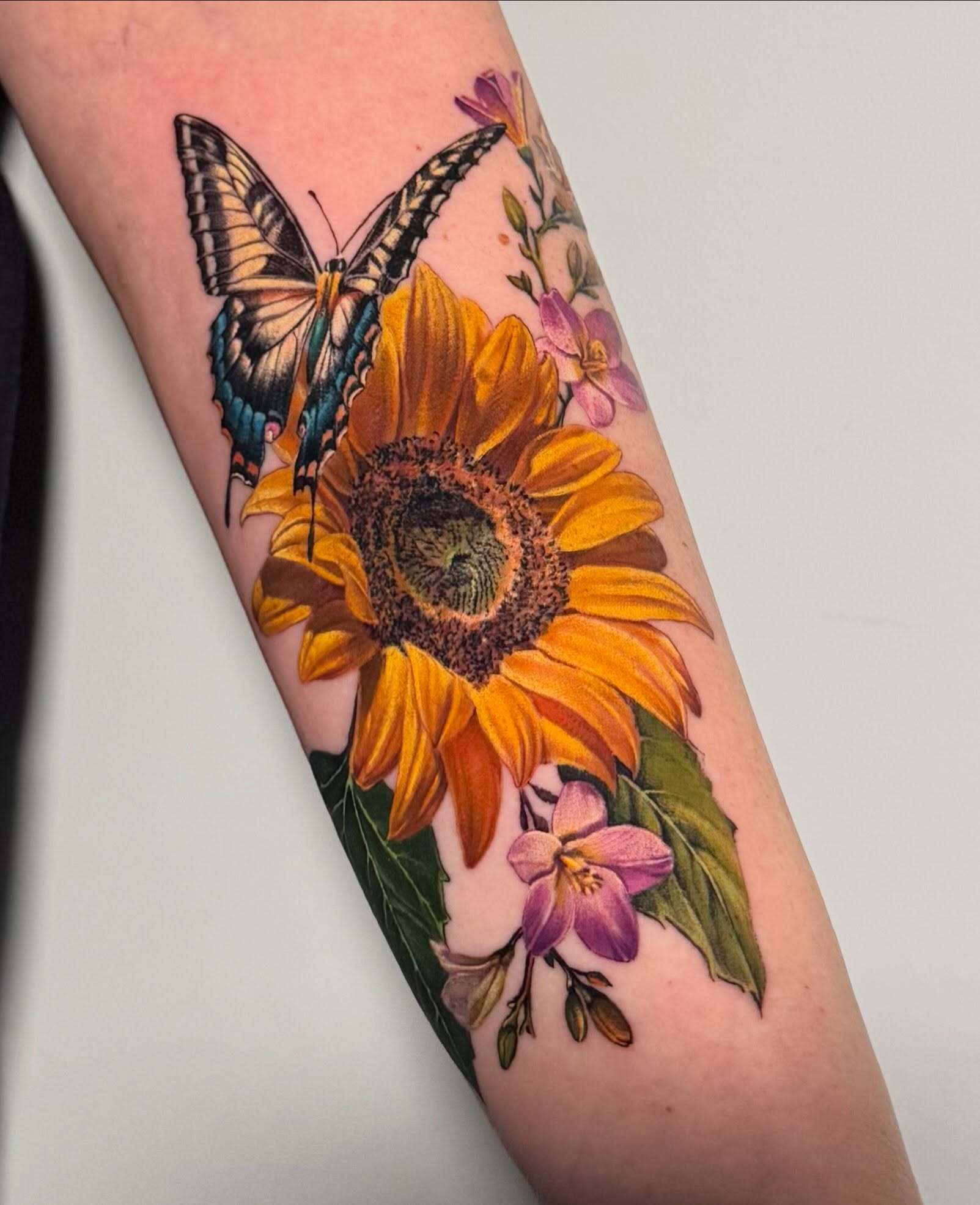 Sunflower and butterfly colour tattoo by Julia Luniko in Winnipeg